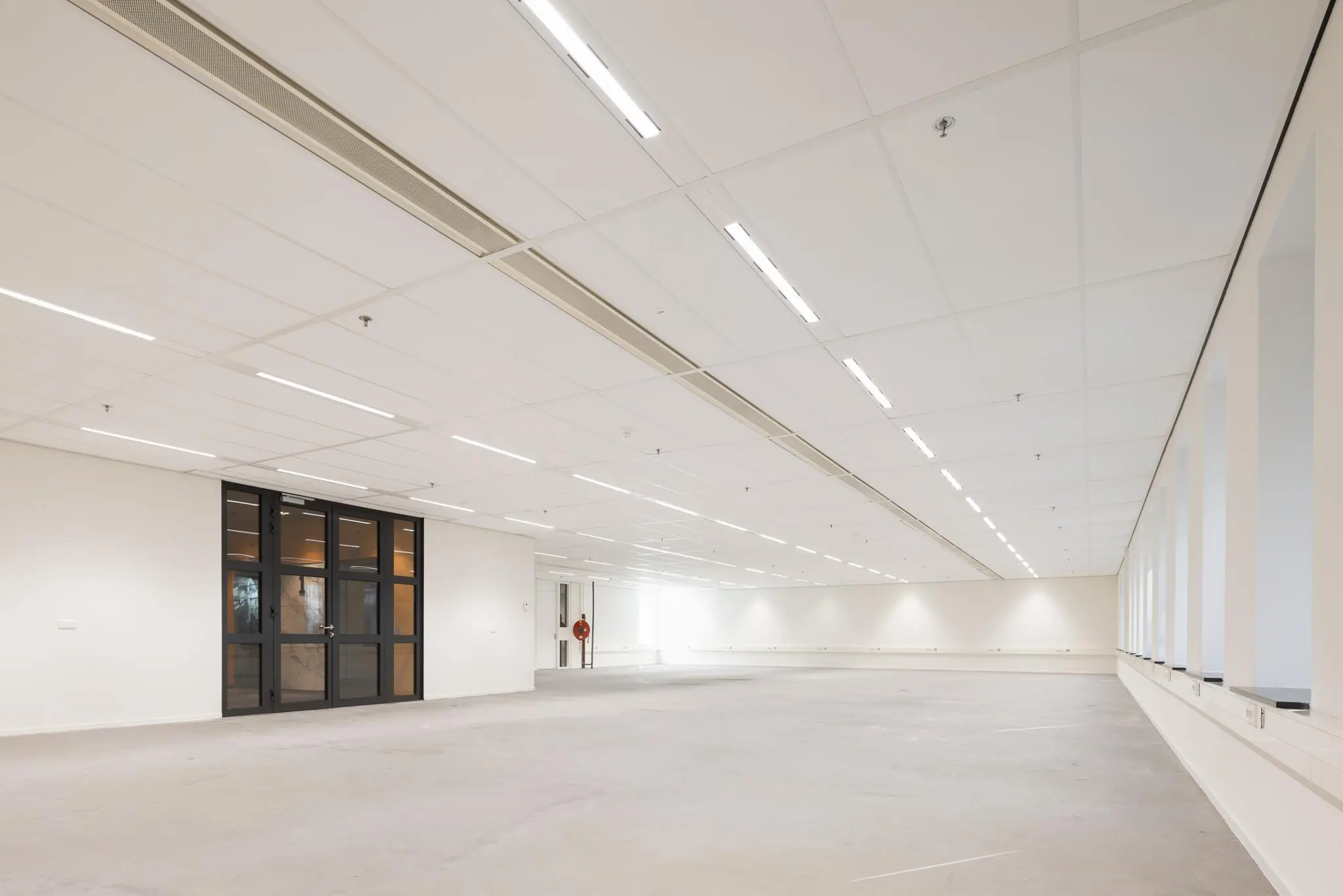 Leeg kantoorpand aan de Prinses Beatrixlaan met systeemplafond, grote raampartijen en glazen binnendeuren.